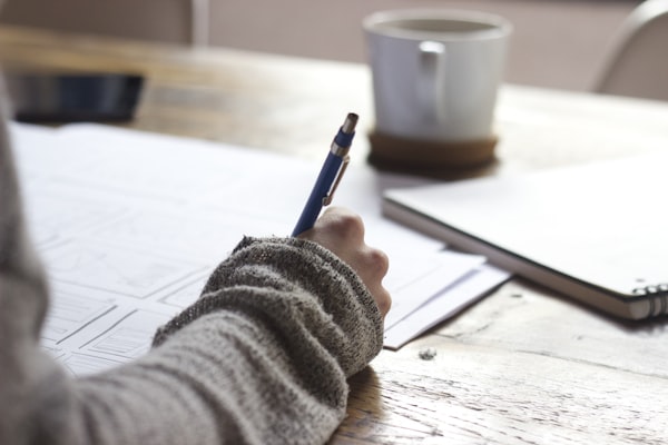 Hand die notities schrijft aan een bureau